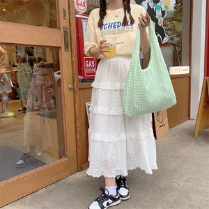 Green checkered canvas tote bag shown in a vintage street style outfit with model