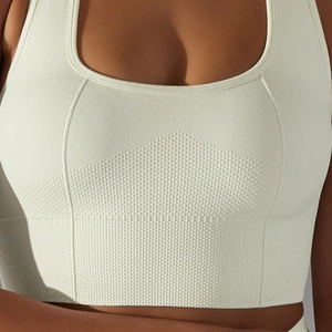 Macro detail of white seamless sports bra with honeycomb texture and reinforced stitching