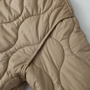 Close-up of onion quilting pattern on khaki ripstop fabric showing fine stitching detail