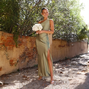 Detail of elegant olive green satin one-shoulder dress with high side slit for women