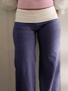 Detail of navy striped wide-leg trousers with wide white fold-over high waistband