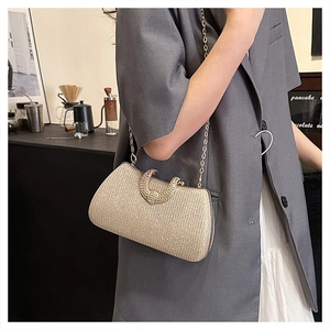 Detail of elegant gold glitter shoulder bag with sparkling rhinestone clasp and chain