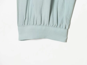 Detailed view of elastic ruffled cuff on a light blue viscose fabric blouse