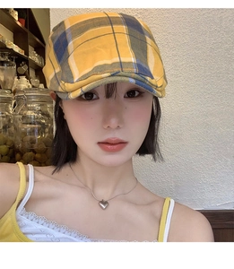 Détail d'une casquette gavroche vintage à carreaux jaune et bleu sur un mannequin