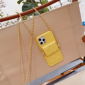 Detail of yellow quilted leather phone case with gold chain strap and card holder