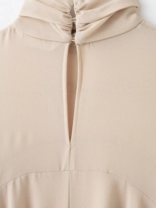 Macro shot of apricot layered chiffon blouse showing the high neck pleats and back keyhole