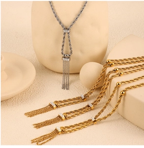 Détail de colliers à chaîne torsadée double avec bague en zircon et pompons