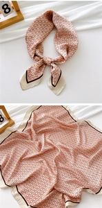 Close-up of pink square silk scarf featuring geometric chain patterns and contrast borders