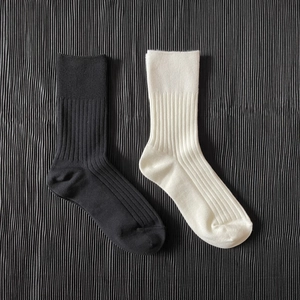 Detailed view of black and beige ribbed knit stockings in soft cotton texture
