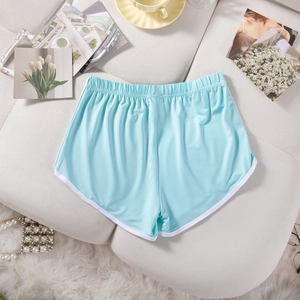 Flat lay of light blue yoga shorts with white trim and elastic waistband on soft fabric