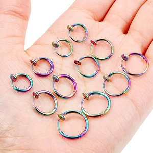 Rainbow stainless steel clip-on earrings held in hand showcasing small size and vibrant colors