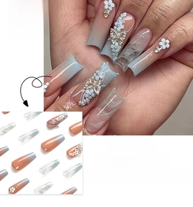 Detail of blue and pink gradient press-on nails with 3D floral and butterfly accents