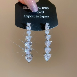Macro shot of S925 silver earrings featuring six gradient heart-shaped zirconia stones