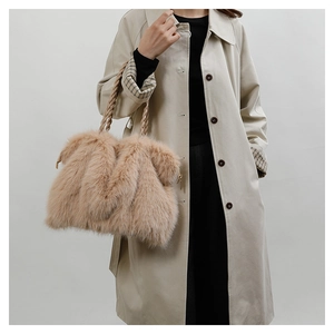 Detail of plush khaki faux fur tote bag with braided rope handles on beige coat