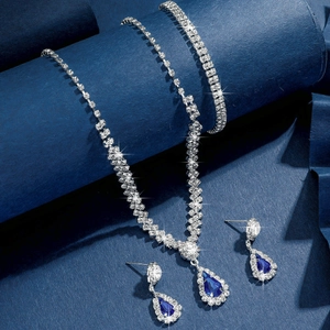 Gros plan sur parure de bijoux de mariée argentée avec pierres bleues en goutte