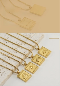 Détail de pendentifs carrés en acier inoxydable plaqué or 18K avec ailes et couronnes