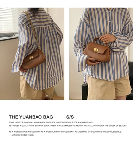 Detail showing brown leather yuanbao bag with metal chain strap and sleek lock closure