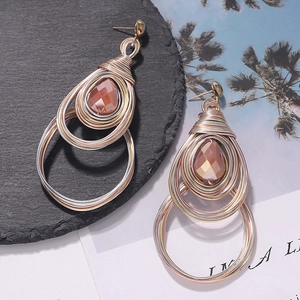 Bohemian handmade wire wrapped heart earrings with amber gemstone accents on stone background