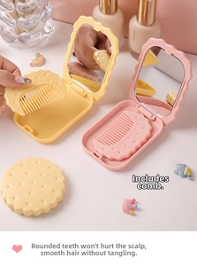 Close-up of portable biscuit-shaped mirror and comb set in cute pink aesthetic design