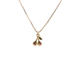 Detail of a gold plated cherry pendant with red and green crystals on a box chain
