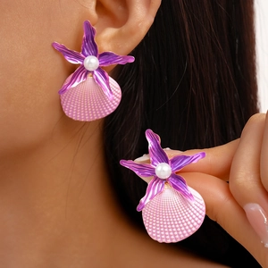 Tropical starfish and shell stud earrings with pearls shown on model for beach vacations