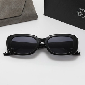 Detail of black rectangle sunglasses with high-gloss frame and textured folding storage case