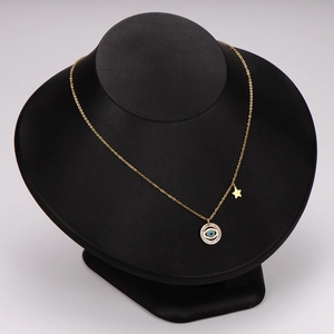 Gold evil eye necklace with blue gemstone, star charm and diamonds on black bust display