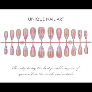 Detailed flat lay of pink and white press-on nails with 3D bows and snowflake designs
