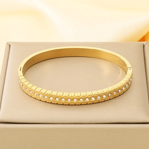 Detail of 18K gold-plated bangle with engraved hearts and sparkling crystals