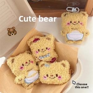 Set of four cute warm yellow plush bear pendants with red hats and blue bows in a gift box