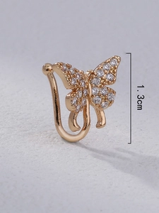 Macro shot of a 1.3cm gold butterfly nose clip with sparkling inlaid crystals