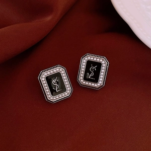 Vue détaillée de boucles d'oreilles vintage dorées avec incrustation noire et perles