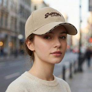 Beige baseball cap with SUNRISE SUNSET embroidery on a female model in an urban setting