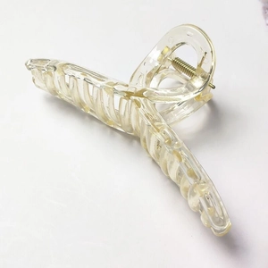 Detail of transparent champagne hair claw clip with cross-teeth design and metal spring