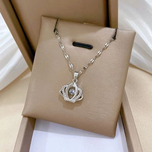 Detailed close-up of a silver crown necklace with a floating dancing stone on jewelry box