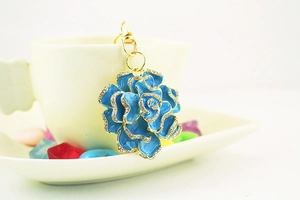 Detailed close-up of blue enamel rose keychain with sparkling rhinestones and golden clasp