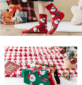 Close-up of festive Christmas socks featuring snowman and reindeer patterns in red and green