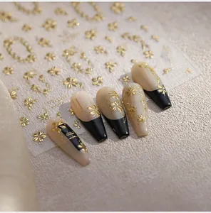 Macro detail of M-891 embossed gold floral nail stickers on pink and black manicure