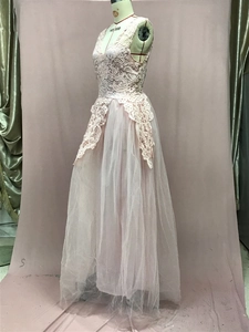 Detailed view of layered tulle skirt and delicate floral lace stitching on pink maxi dress
