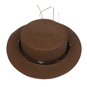 Macro view of dark brown woven straw hat with black leather band and silver bull buckle