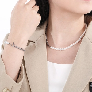 Detail of pearl and silver chain necklace set with OT clasp on female model