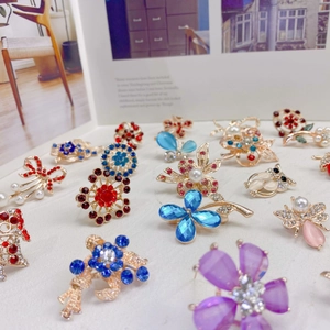Assorted alloy rhinestone brooches featuring floral, butterfly, and owl shapes in gold finish