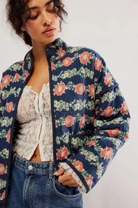 Detail of floral quilted jacket with vintage pattern and delicate lace trim on cuffs