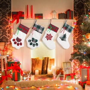 Set of four plaid Christmas stockings with pet paw and snowflake hanging on a fireplace
