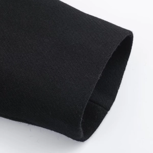 Close-up of black wool blend coat sleeve showing premium twill fabric texture and stitching