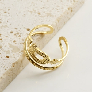 Adjustable 18k gold plated stainless steel hollow crown ring on a travertine stone