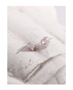 Macro detail of S925 silver stud earrings with heart-shaped pink zircon stones