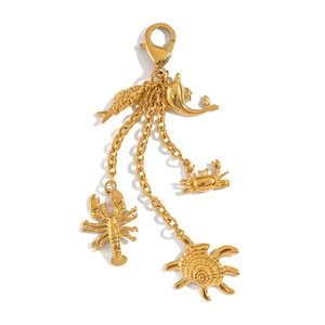 Detail view of five golden ocean charms including a dolphin, crab, and lobster keychain