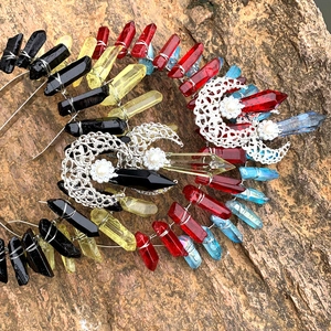 Handmade crown headband with natural colorful crystals and silver moon charms on rock background