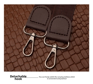 Detail of vintage silver hooks and woven embossed leather on brown travel backpack